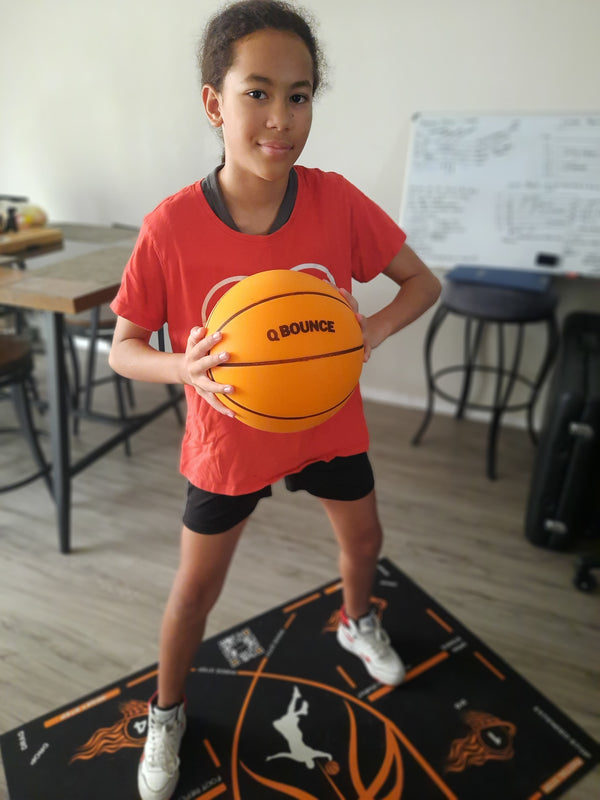 Young player holding the QBounce ball on the training mat