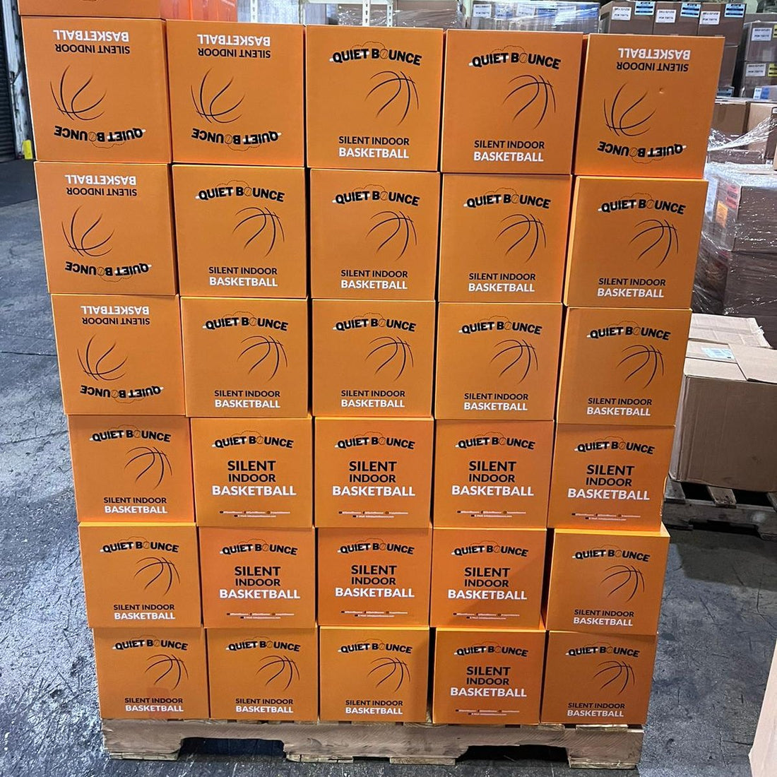 Stacked orange boxes of QBounce Silent Basketball 3.0 labeled for silent indoor basketball training and play.