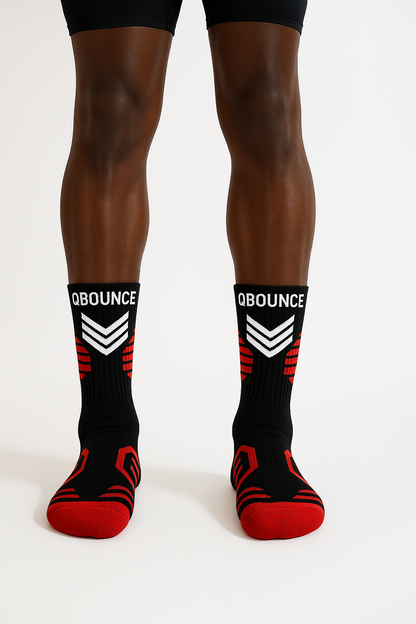 Black and red QBounce Grip Socks worn on legs, designed for enhanced agility and grip during activities.